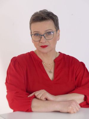 Joanna Garnier, współzałożycielka Fundacji „La Strada” - ubrana w czerwoną sukienkę, patrzy uważnie prosto w oczy, 