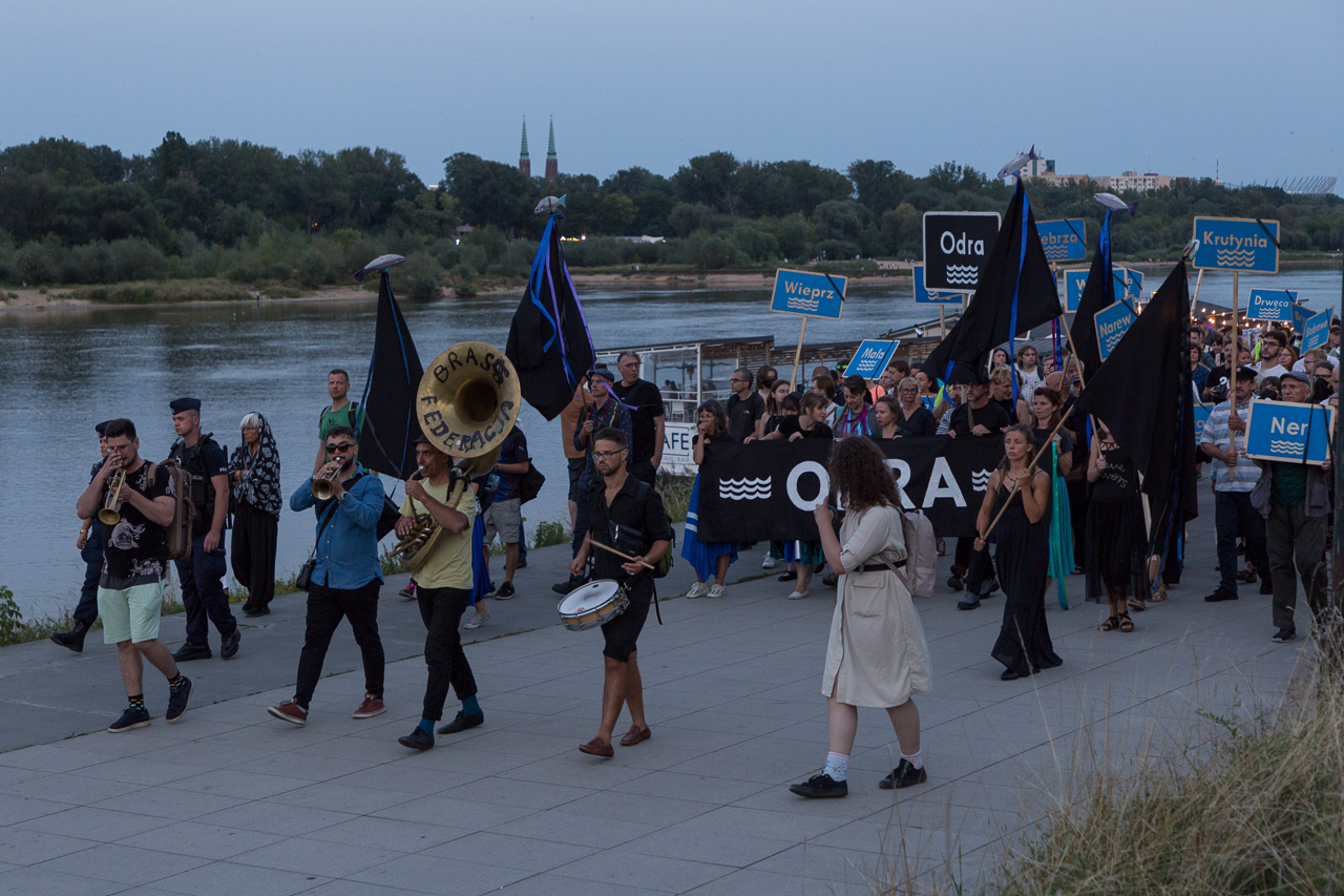 Demonstranci idą bulwarami nad Wisłą. Na czele zespół instrumentów dętych