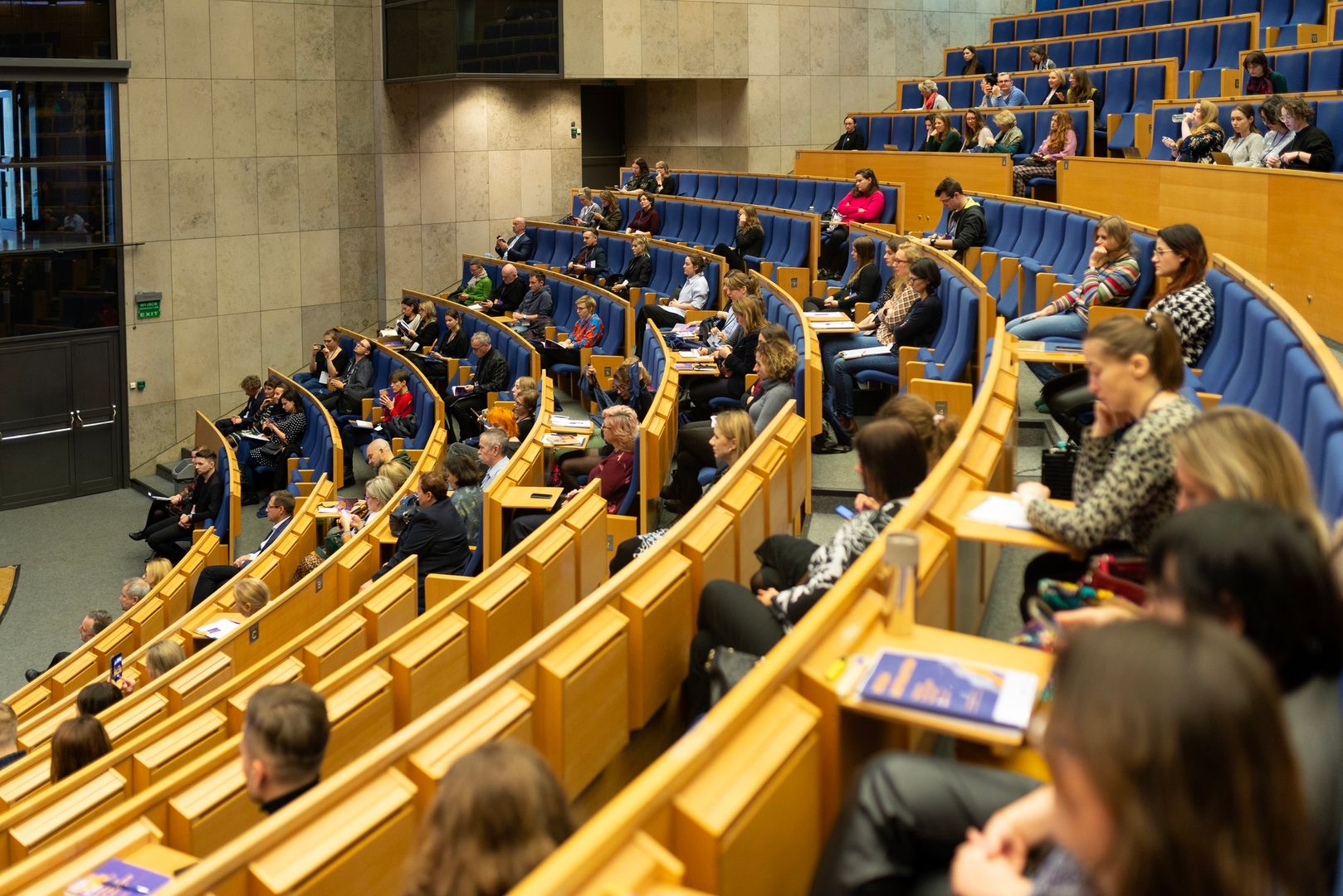 Sala audytoryjna pełna osób czekających na rozpoczęcie konferencji