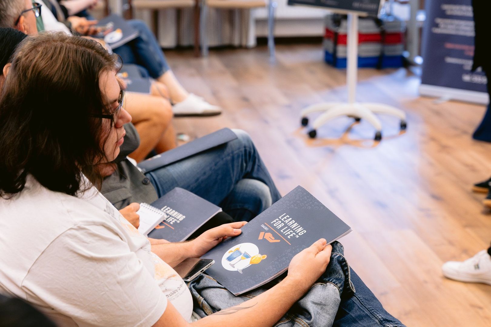 Uczestnicy szkolenia Learning for Life podczas części teoretycznej, trzymają materiały edukacyjne programu.