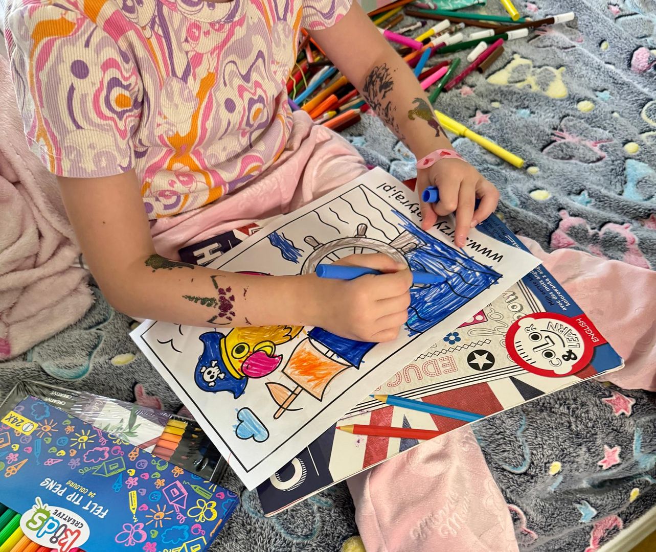 Mała piratka koloruje fundacyjną piracką kolorowankę Skrzydlatego Raju – chwila twórczej zabawy i oddechu od szpitalnej rzeczywistości.papugoterapia, terapia z udziałem zwierząt, fundacja dla dzieci, pomoc dzieciom w szpitalach, onkologia dziecięca, Fundacja Skrzydlaty Raj, papugi, egzotyczne papugi, piraci w szpitalu, kampania Kosmyk dla Małego Pirata, peruki dla dzieci po chemioterapii, wizyty w szpitalach, zajęcia edukacyjne z papugami