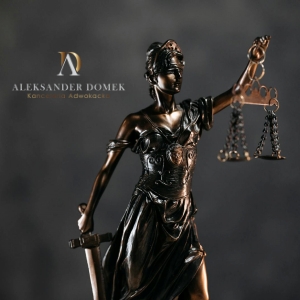 Statuetka wagi sprawiedliwości na ciemnym tle, symbolizująca rzetelne prawo karne i cywilne w Kancelarii Adwokackiej w Bydgoszczy.