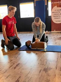 Miniatura instruktor i kobieta ucząca się pierwszej pomocy - uciskająca fantoma